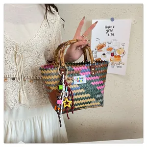 Detail of colorful hand-woven tote bag with bamboo handle and fashion bags label