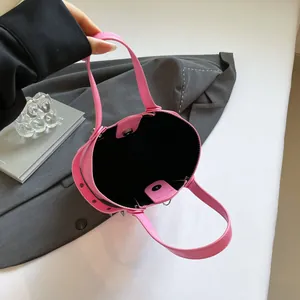 Pink bucket bag with silver studs and cross detail, interior view on a blazer