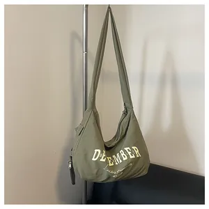 Detailansicht der olivgrünen Nylon-Hobo-Tasche mit gelbem December-Schriftzug und Print