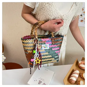 Detail of colorful woven tote with bamboo handles and decorative star charms
