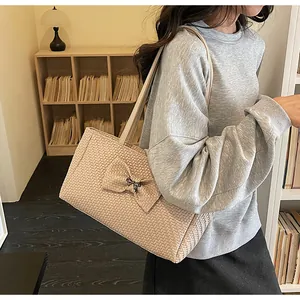 Detailed macro view of beige woven tote bag texture with elegant ribbon bow accessory