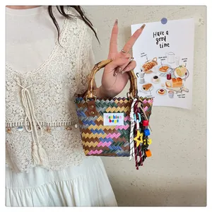 Detail of colorful woven tote with natural bamboo handles and star charms