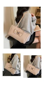 Detail of woven beige tote bag with a bow decoration and metal fastener accent