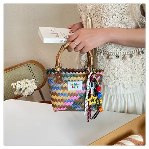Detail of hand-woven colorful tote with bamboo handle and stylish bead accessories