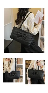 Detail of black woven tote bag with large bow and silver buckle in a bookstore setting