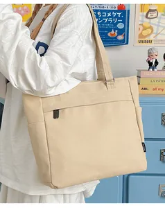 Detail of beige canvas tote bag with functional zipper pocket and side compartments