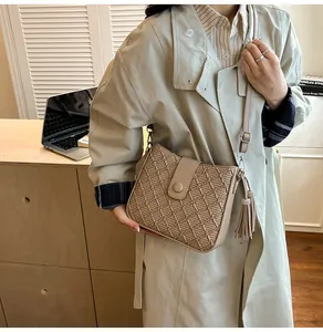Détail du sac seau kaki avec gaufrage texturé et décoration de pompon élégant