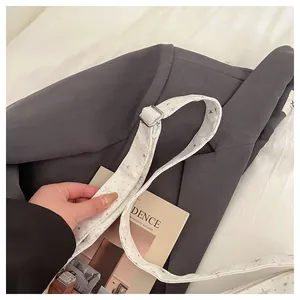 Close-up of adjustable white shoulder strap with grey star patterns and silver buckle