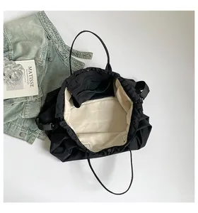 Dettaglio borsa nera con coulisse con fodera bianco crema e scomparti interni