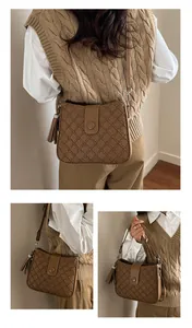 Détails du sac seau marron avec texture géométrique, pompon et bandoulière ajustable