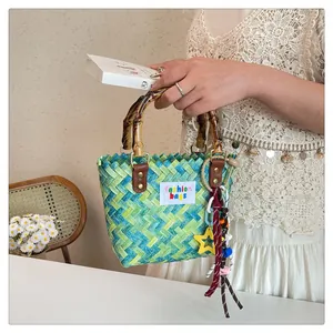 Macro detail of colorful woven beach bag with bamboo handles and vibrant tassel charms