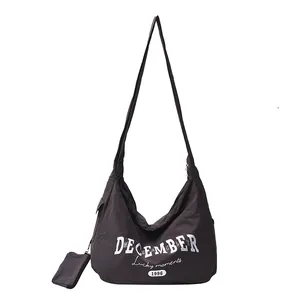 Minimalistische große Nylon-Umhängetasche mit December-Aufdruck und kleiner Seitentasche