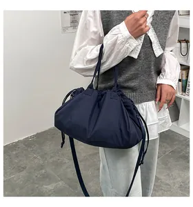 Dettaglio borsa tote in nylon blu scuro con trama a pieghe e chiusura a coulisse