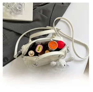 Top view of cream Boston bag showing internal capacity for phone and cosmetics