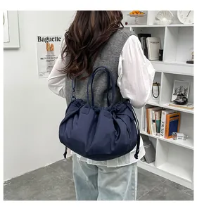Dettaglio della borsa tote in nylon blu navy con coulisse, design a pieghe e manici tondi