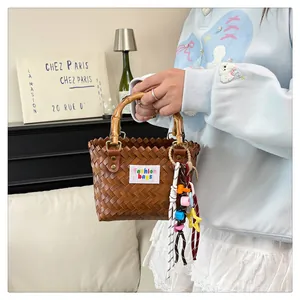 Detail of woven straw bag with natural bamboo handle and colorful star tassel charm