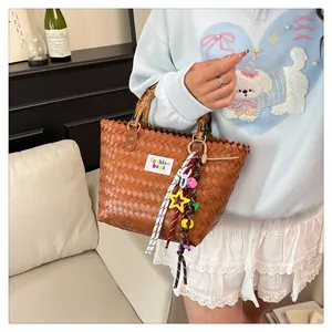 Detail of woven beach bag featuring a bamboo handle, star charms and fashion stickers