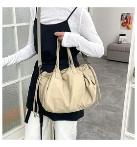 Dettaglio della borsa beige con coulisse con ganci vintage e ampia tracolla