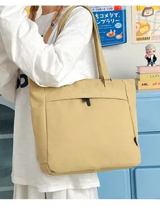 Close-up of a khaki canvas tote bag with functional pockets and a sturdy zipper detail