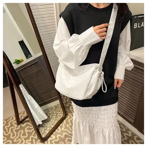 Chic white shoulder bag with star pattern shown with matching black and white casual outfit