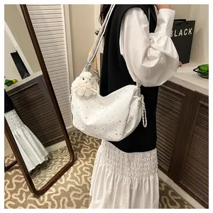 Detailed shot of a white half-moon hobo bag with star prints and a plush bunny charm