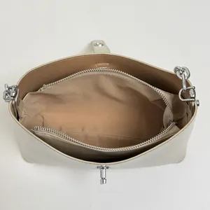 Internal view of beige leather bag with center zipper pocket and dual compartments