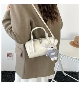 Detail of cream white Boston bag with silver hardware and cute rabbit charm strap