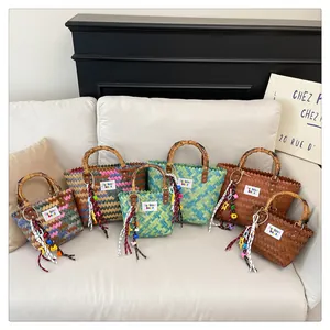 Detailed view of woven hand-woven beach bags with vintage bamboo handles and colorful tassels