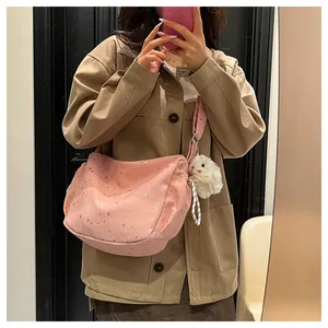 Pink canvas tote bag with silver star pattern and plush rabbit pendant on a wide strap