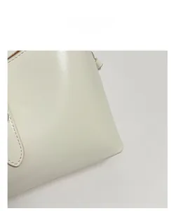Detailed macro view of cream underarm bag with premium leather texture and stitching