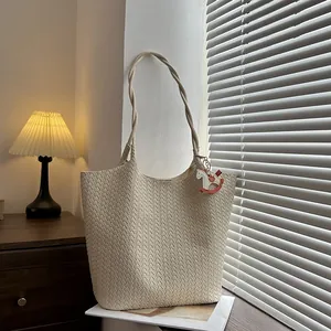 Secchiello minimalista in pelle intrecciata beige con manici e ciondolo a cavallo