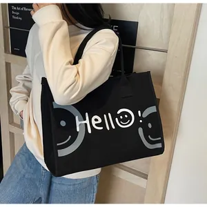 Detail of black canvas tote bag showing side thickness and white Hello smile print