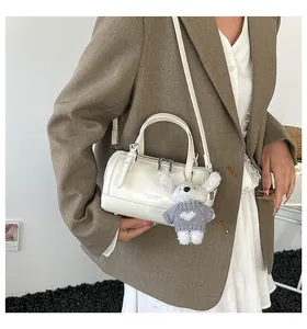 Polished white Boston bag featuring dual handles and a cute rabbit pendant accessory