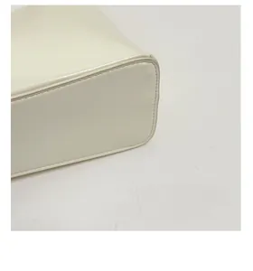 Detail of the widened reinforced bottom of this cream faux leather shoulder bag