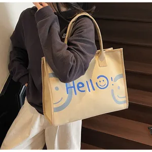 Detail shot of the large canvas tote bag featuring a blue Hello print and smile emoji