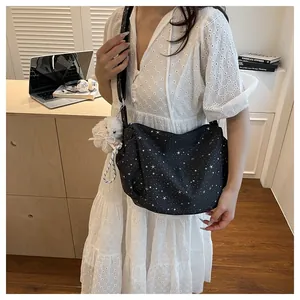 Close-up of black star pattern shoulder bag with a cute white bunny plush pendant