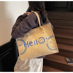 Detail view of a large canvas tote bag with Hello print shown on a wooden staircase