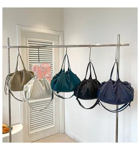 Cinque colori di borse tote in nylon con coulisse appese per il pendolarismo quotidiano