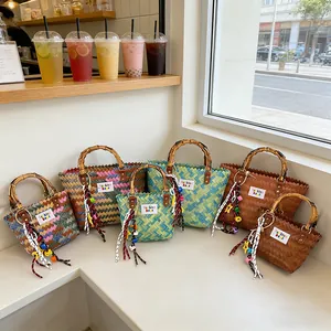 Handwoven straw beach bags with retro bamboo handles and colorful tassels in various patterns