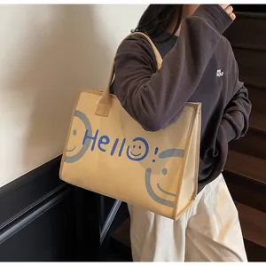 Detailed texture of beige canvas tote bag with Hello print and grey smiley face pattern