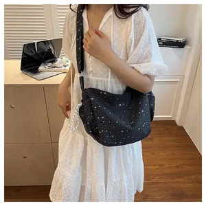 Detail of black half-moon tote bag with white star pattern and adjustable strap
