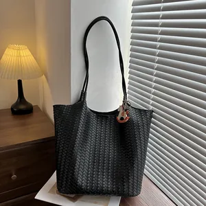 Secchiello intrecciato nero minimalista con ciondolo a cavallo su superficie in legno