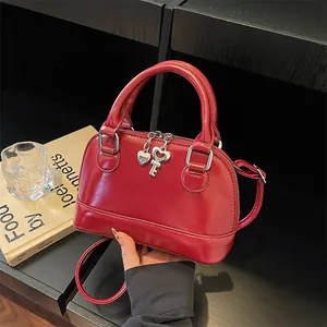 Glossy red shell bag with silver heart charm and crossbody strap for fashion women