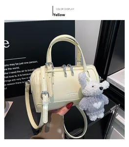 Detailed top view of cream Boston bag with silver zipper and cute plush bear charm