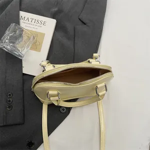 Minimalist light yellow shell bag with silver zipper and smooth PU leather finish