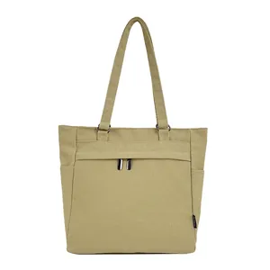 Khaki canvas tote bag with shoulder straps featuring front zipper and side pocket details