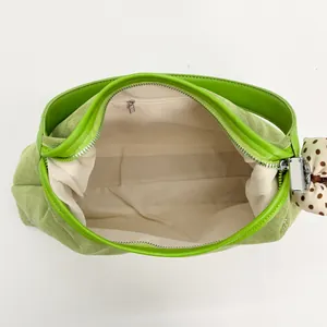 Borsa a spalla verde brillante in camoscio con finiture lisce e fiocco a pois marroni
