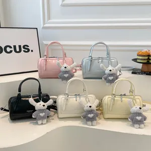 Glossy Boston bags in five colors with cute rabbit charms on a white display stand