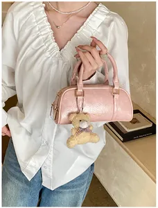 Détail du sac Boston vintage rose avec texture cuir froissé et un charm d'ours en peluche