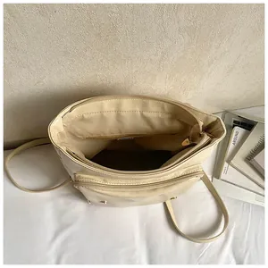 Vista dall'alto dell'interno della borsa in ecopelle crema con scomparti multipli con zip